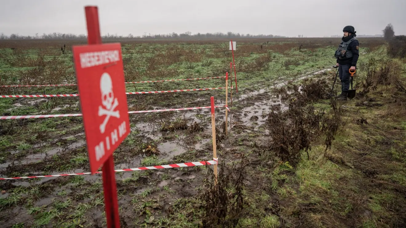 Marked minefield with warning sign showing dangerous manual clearance conditions